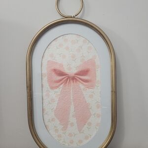 Viral Pink Bow Wall Art with floral background in oval gold frame